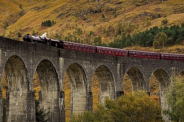 Experience the magic of Scotland with the iconic Glenfinnan Viaduct as the Hogwarts Express crosses surrounded by stunning highland scenery and a touch of cinematic history.